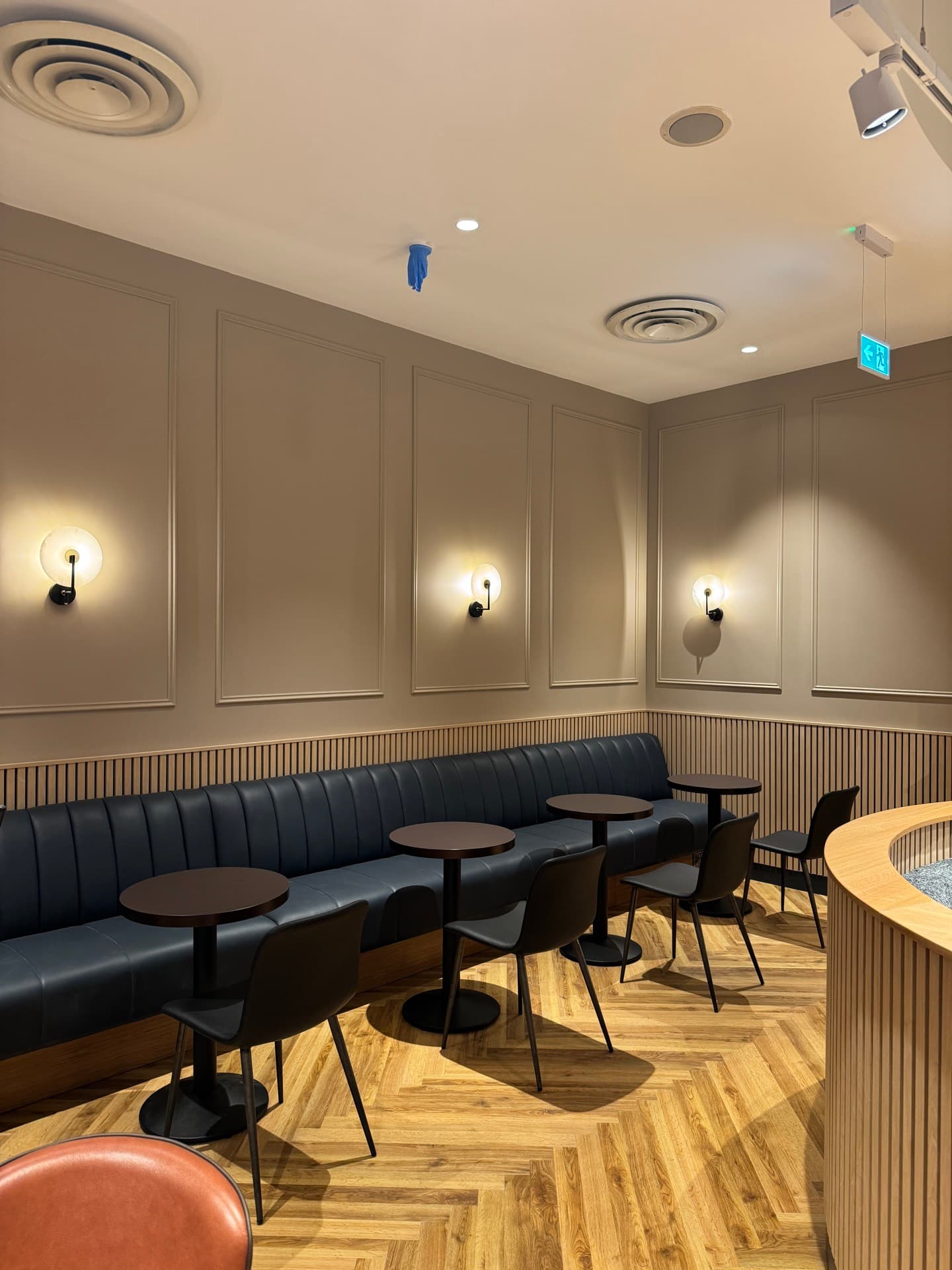 Row of decorative wall sconces along booth seating with track lighting and emergency lighting at Insomnia Liffey Valley
