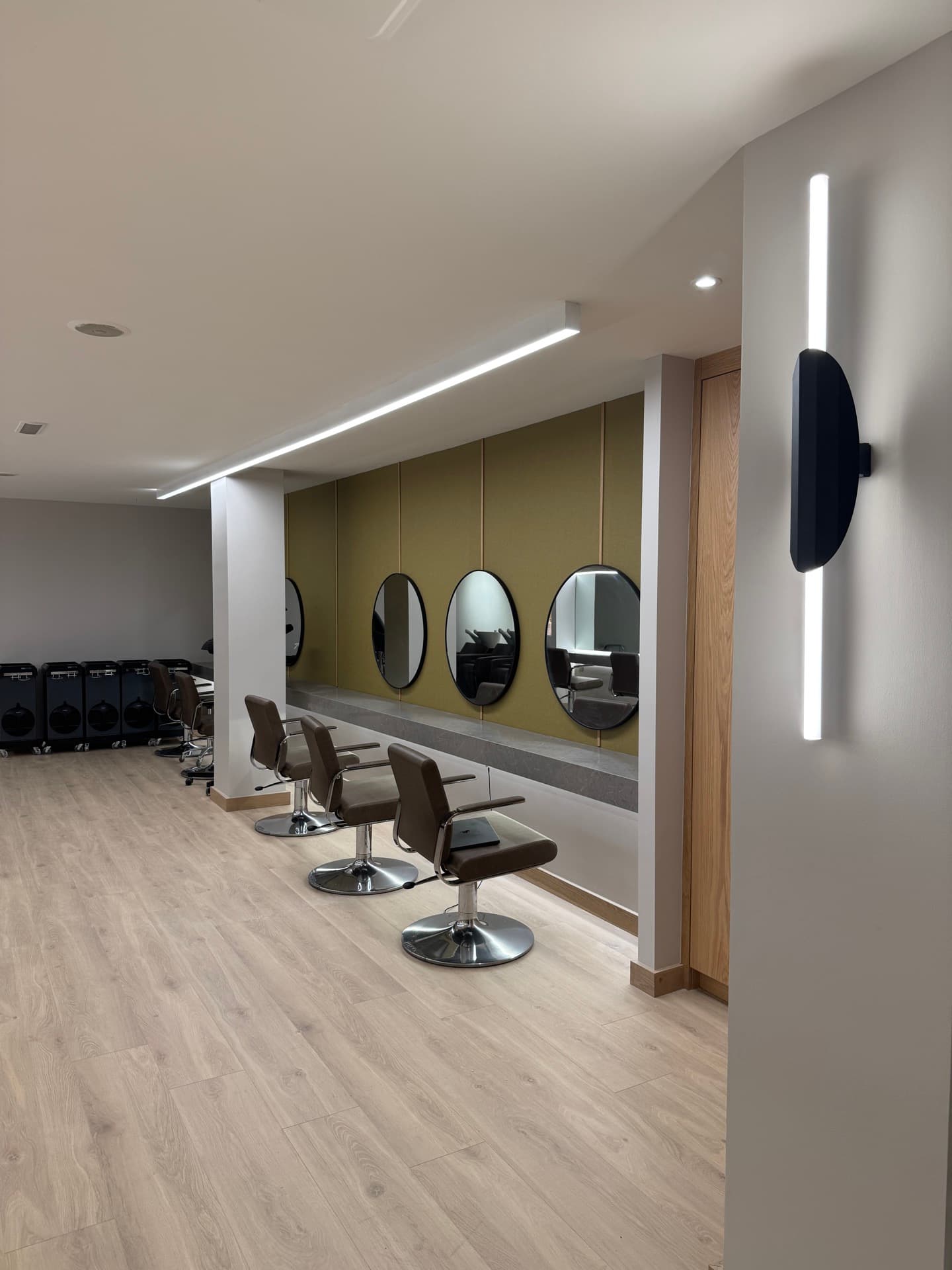 Styling stations at Zebra Hair Dressers with LED strip perimeter lighting, overhead pendant, and circular mirrors
