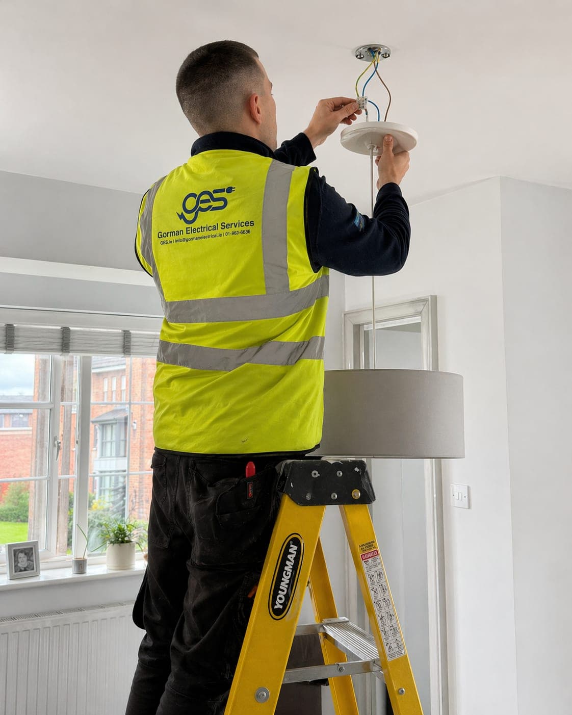 GES electrician installing a pendant light — professional electrical work in Dublin 8